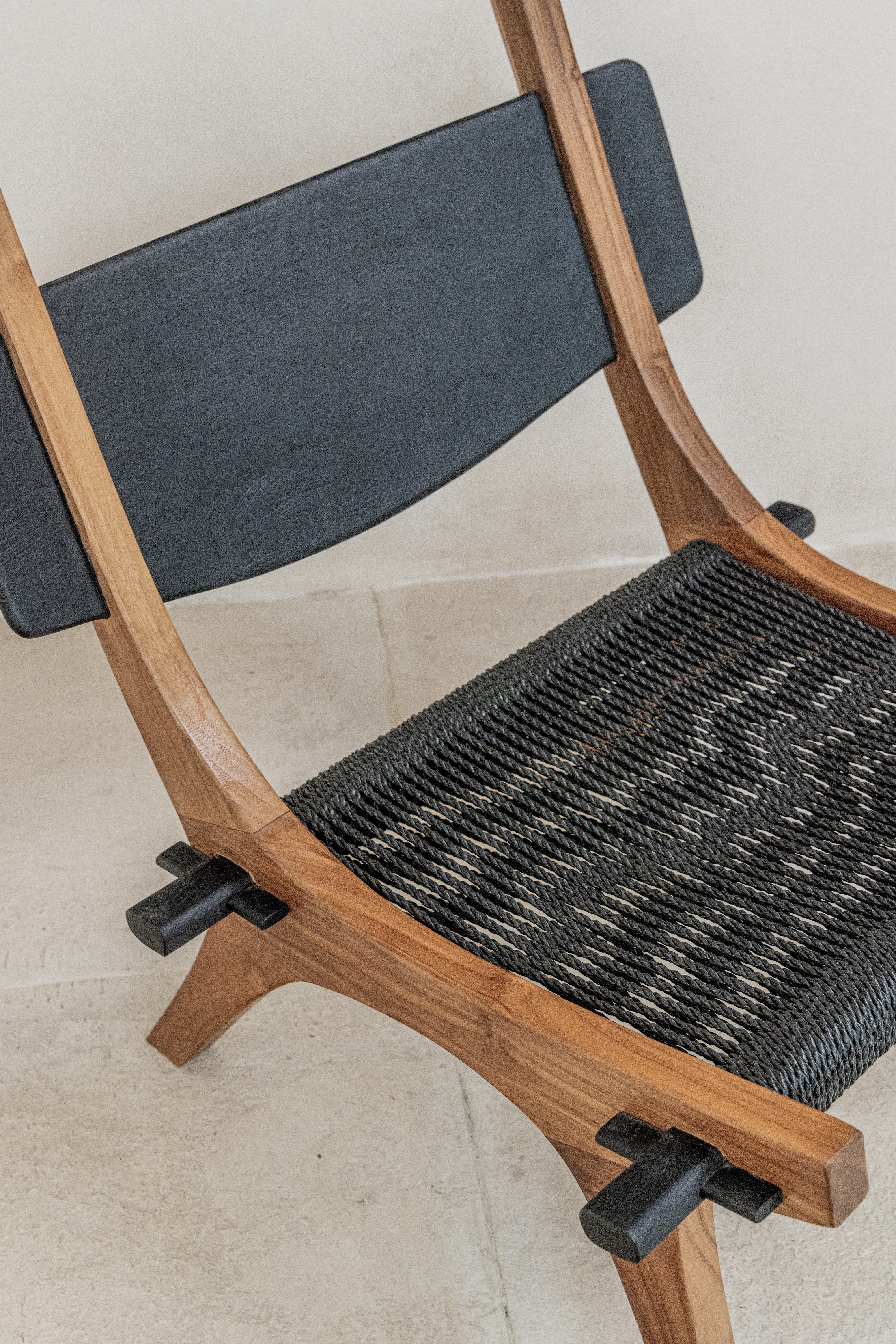 Spanish inspired teak lounge chair with woven rope seat in black