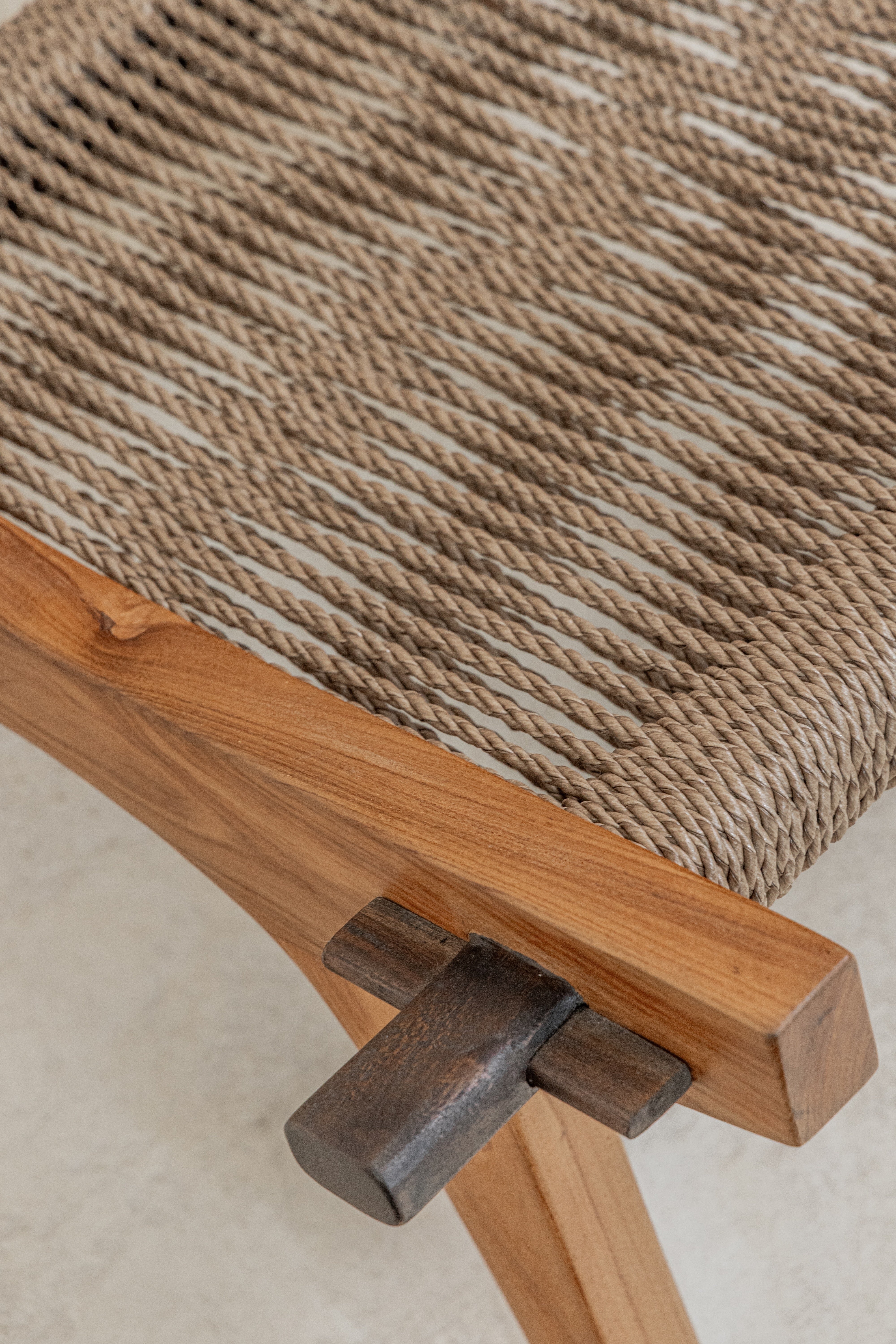 Spanish inspired teak lounge chair with detail of woven rope seat