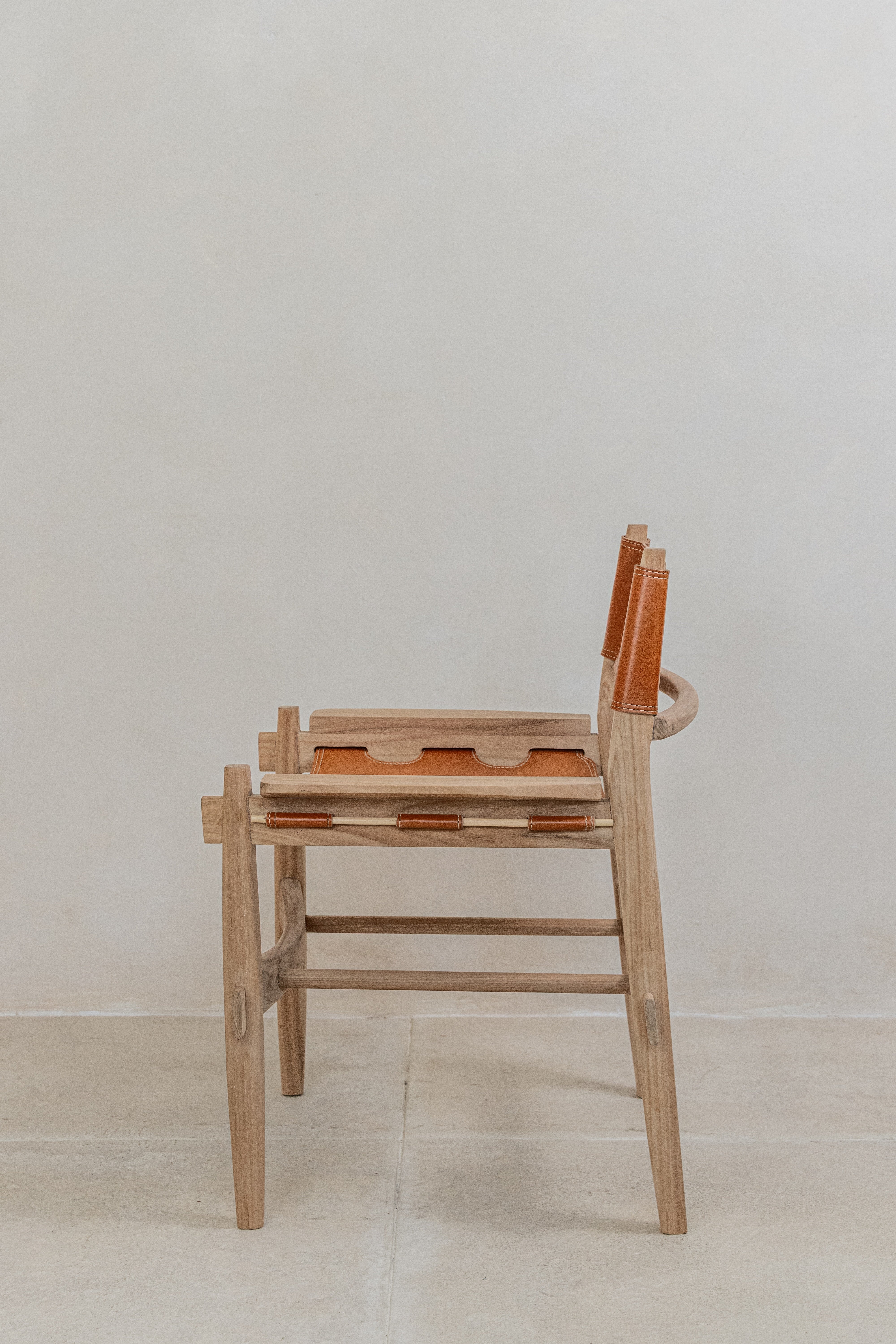 Sergio leather sling dining chair on a solid teak frame side view