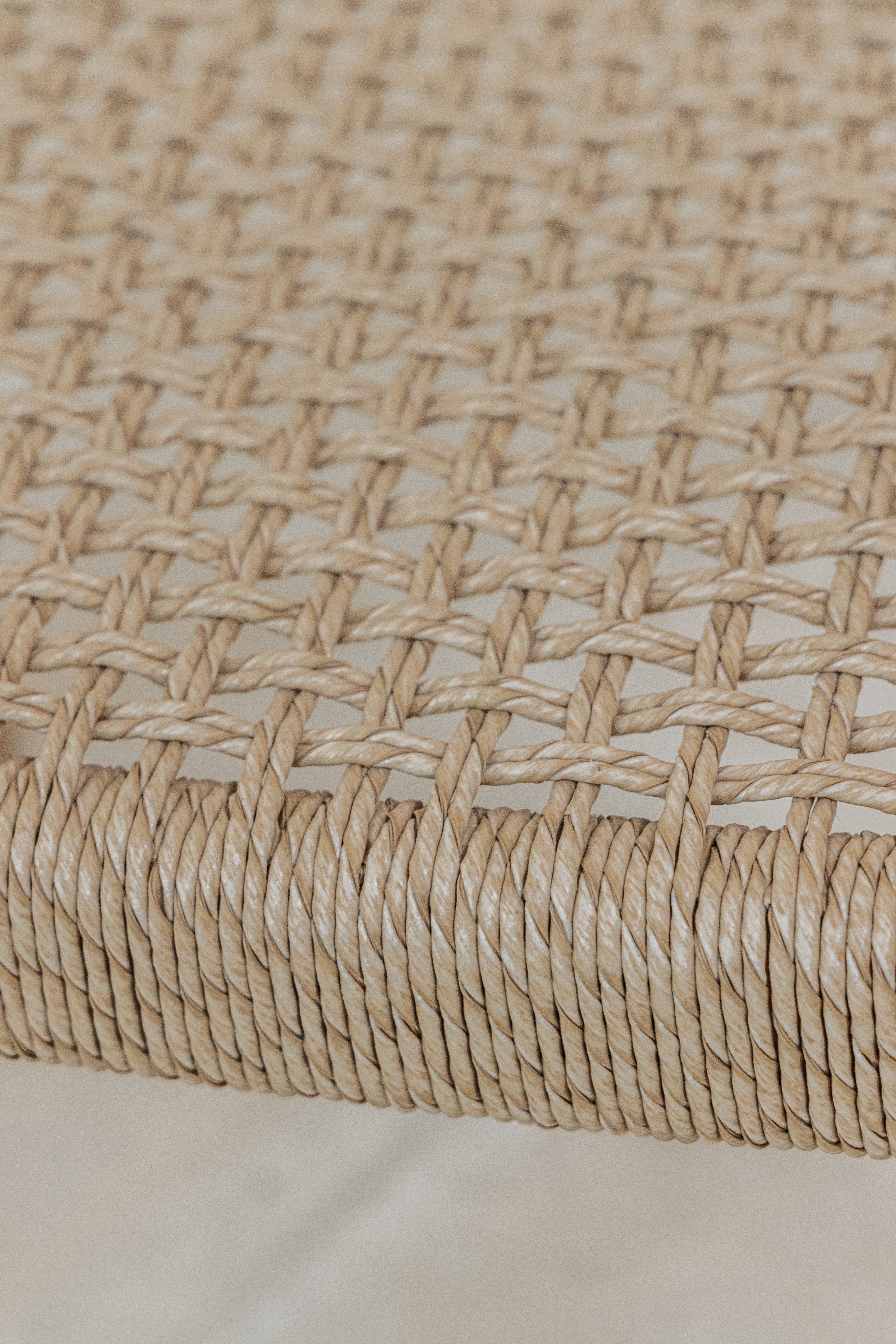 Close up of the woven wicker seat on the Lila teak dining chair