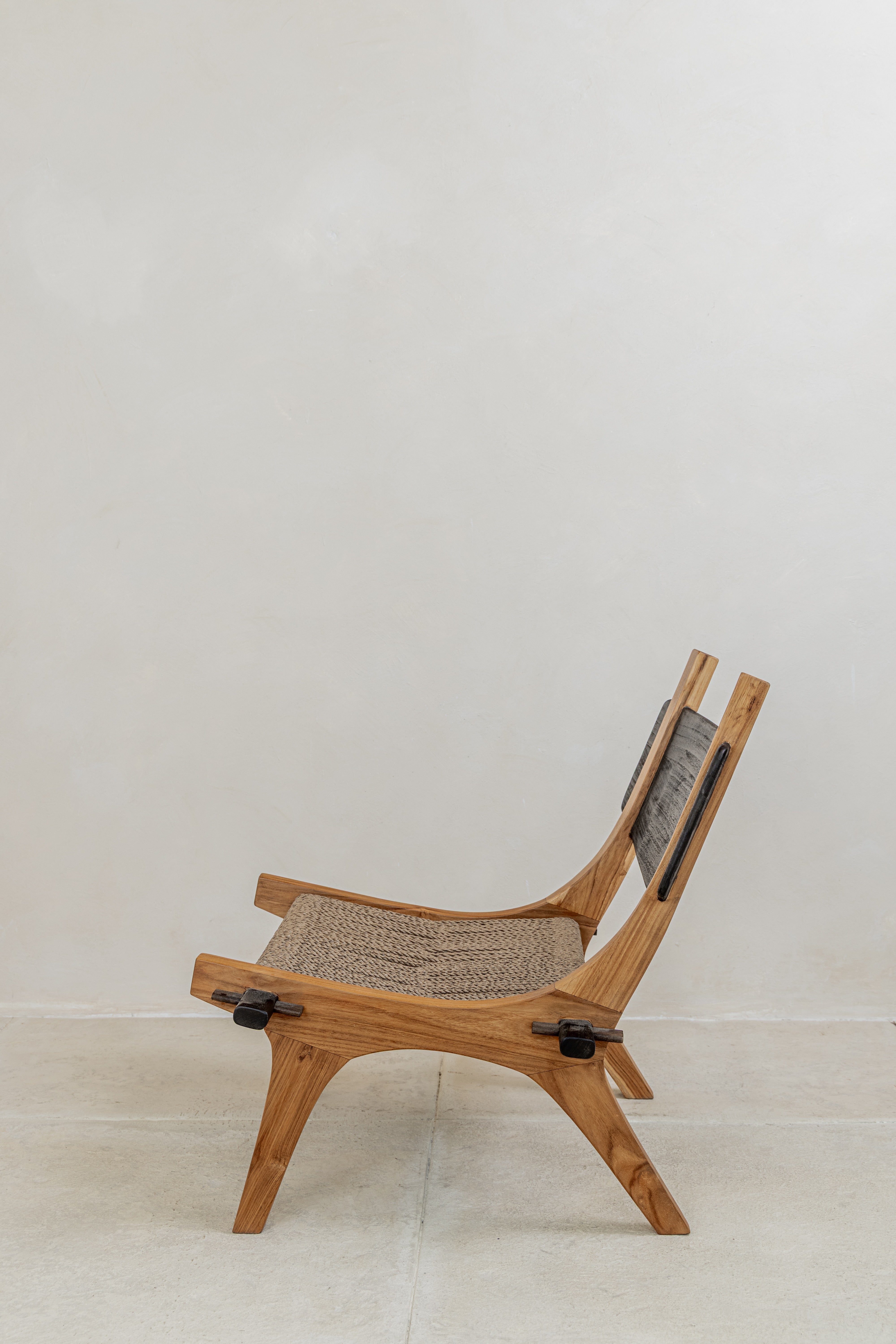 Spanish inspired teak lounge chair with woven rope seat side view