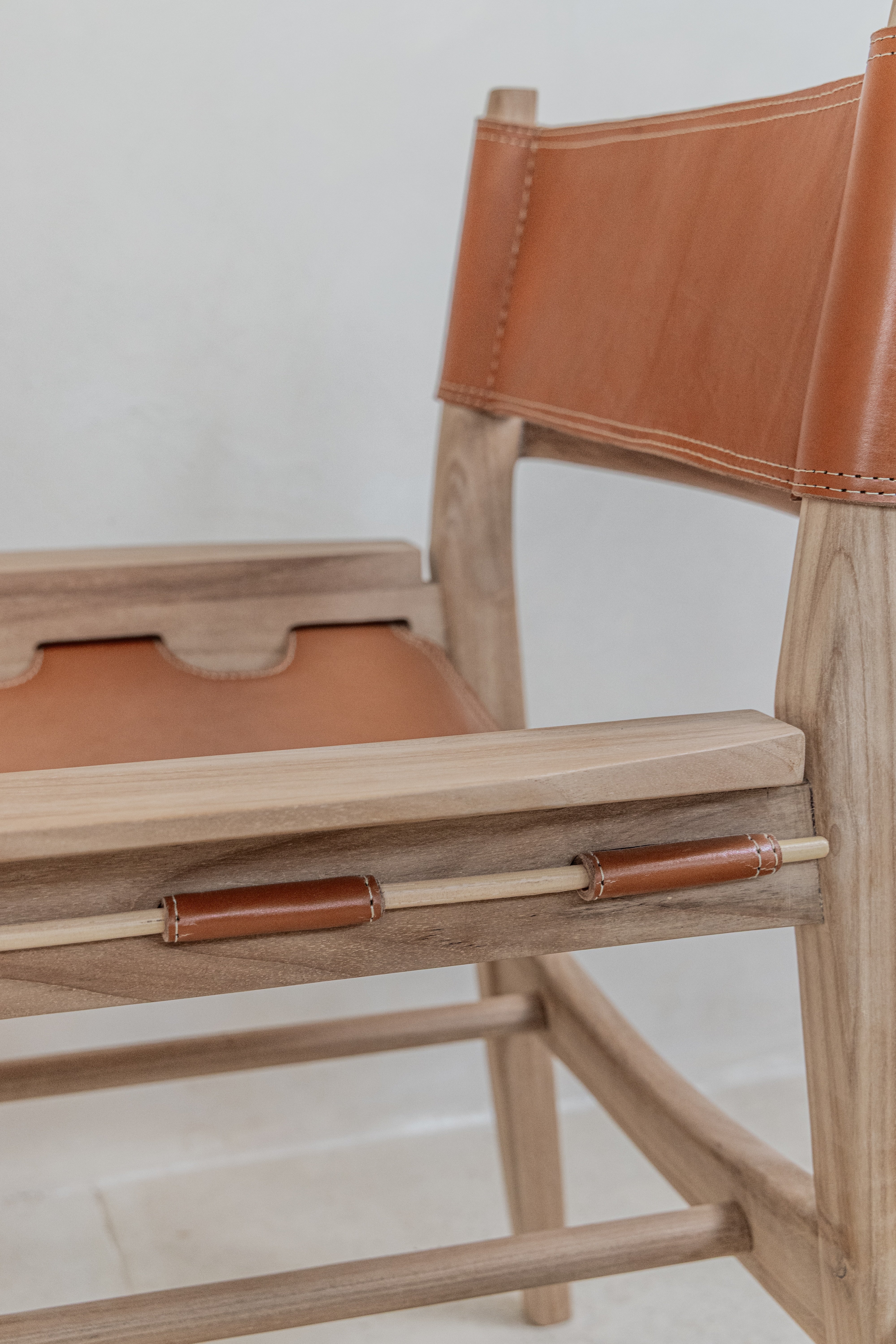 Side view of the hand stitching and joinery of leather seat on the Sergio dining chair