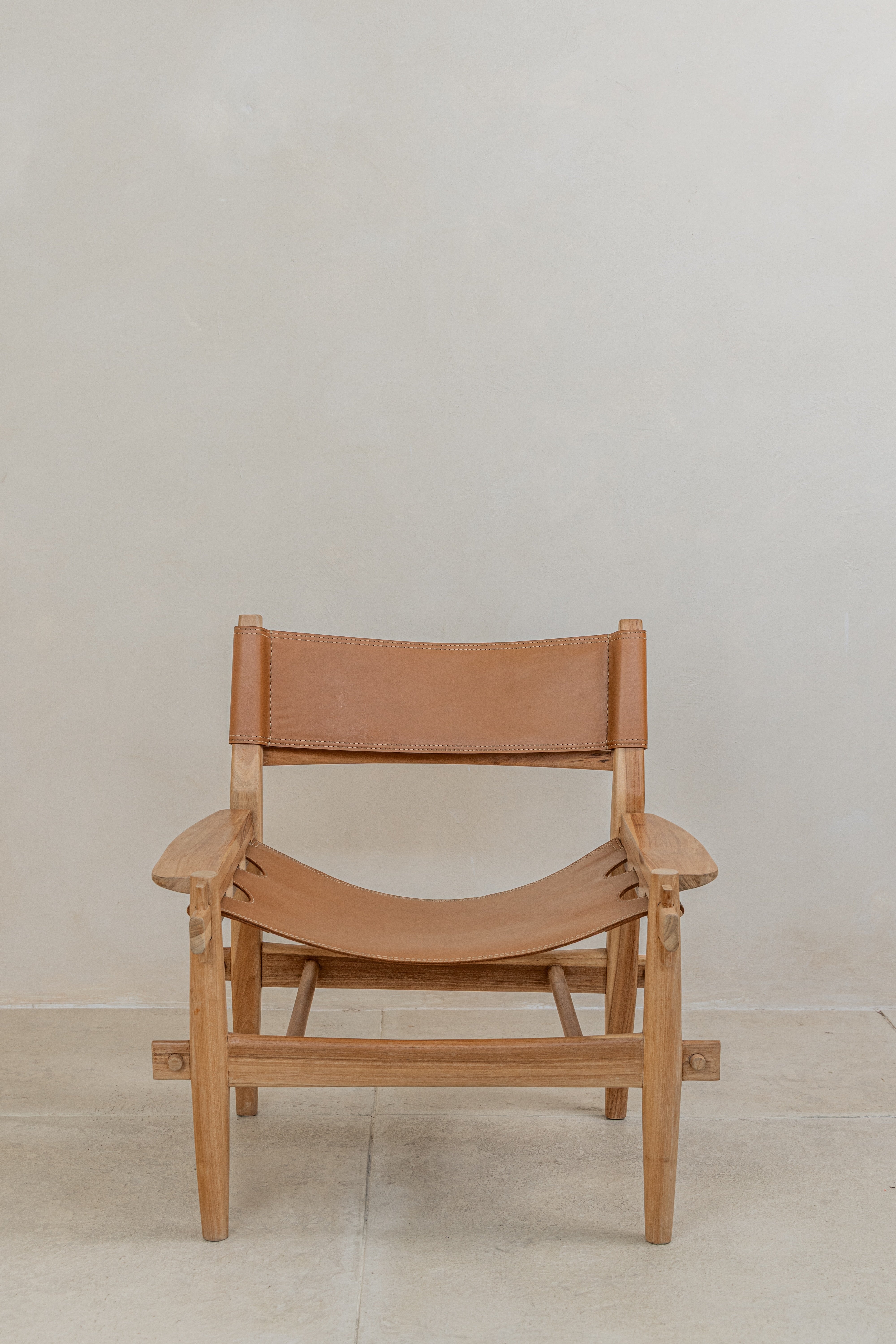 Tan top grain leather sling lounge chair with teak arms and frame